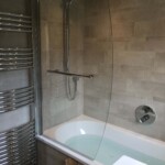 Bath with curved glass shower door in Tilehurst, Reading